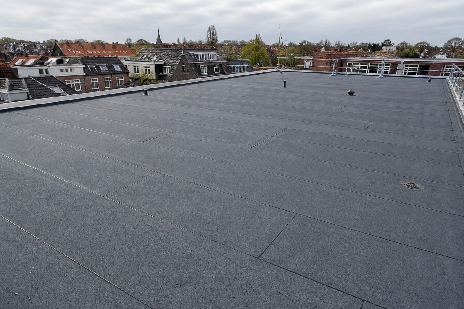 Plat dak met nieuwe bitumen dakbedekking en nette naden